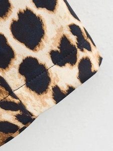 Detailed macro view of leopard print sleeveless dress fabric and stitching quality