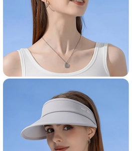 Detail of light grey UPF50+ sun visor with brand logo and silver pendant necklace