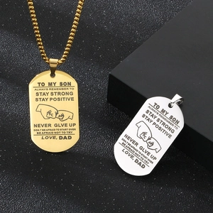Détail de pendentifs militaires en acier or et argent avec texte inspirant du père au fils