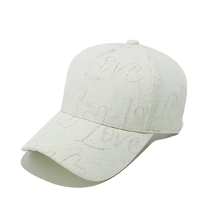 Détail d'une casquette blanche avec lettrage LOVE et motif jacquard à cœurs brodés