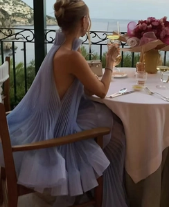 Elegantes rückenfreies plissiertes Maxikleid in Hellblau in einer malerischen Urlaubsszenerie