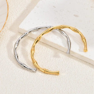 Detailaufnahme der polierten Armreifen im Bambus-Stil in Gold und Silber