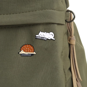 Cute enamel cat and hedgehog badges on green canvas bag with I Need A Hug text