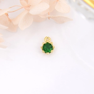 Close-up of 18k gold plated crown pendant with a green zircon stone for DIY jewelry