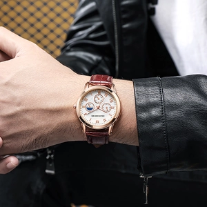 Close-up of men's business quartz watch with white dial and brown leather strap on wrist
