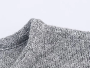 Close-up of grey knit coat collar showing detailed soft wool texture and fine stitching