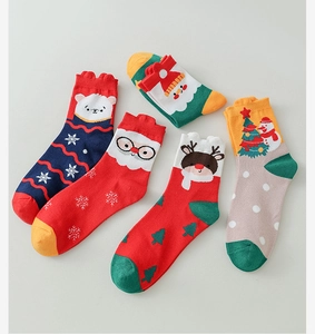 Flat lay of colorful Christmas themed cotton socks featuring Santa, snowmen and reindeer