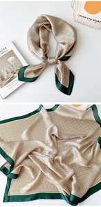 Detail of a square silk scarf featuring a dusty pink geometric pattern with dark green borders