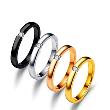 Detailed view of four stainless steel rings in black silver rose gold and gold with zircon