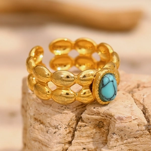 Macro detail of 18K gold-plated double-layer beaded ring with oval turquoise gemstone