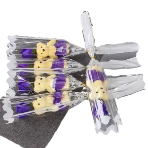Five purple soap rose bouquets with plush teddy bears in transparent gift packaging
