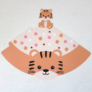 Flat lay of tiger-themed jungle party hat made of premium cardboard on white wood