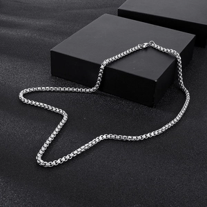 Polished silver stainless steel square pearl box chain with lobster clasp on black background