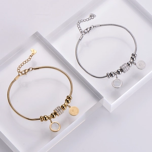 Vue détaillée de bracelets en maille serpent dorés et argentés avec pendentifs de pièces de monnaie