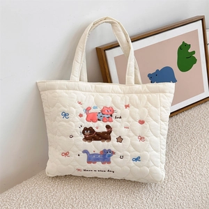 Close-up of heart-shaped quilted fabric with colorful kitten embroidery and Luck text