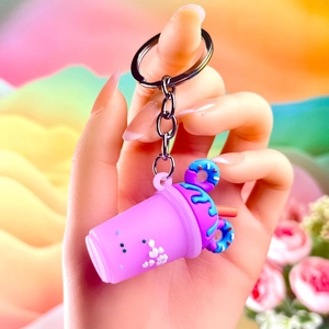 Close-up of a cute mini beverage cup keychain with pink body and blue donut topping