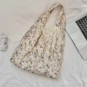 Detail of floral tote bag with a white lace bow and vintage aesthetic on fabric