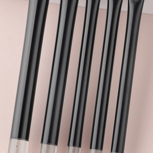 Detail of 5 mini makeup brushes with crystal glitter handles on a soft pink background