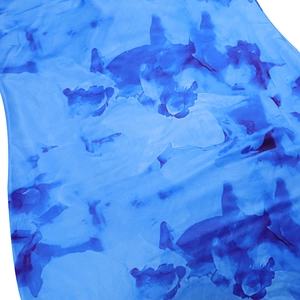 Close-up of blue textile fabric featuring dark blue shark silhouette print patterns