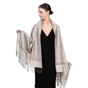 Dettaglio dello scialle jacquard grigio argento con motivo paisley e nappe sfrangiate