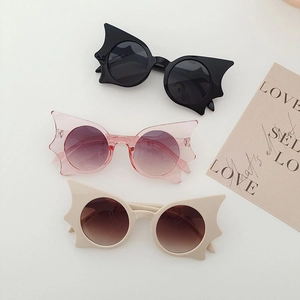 Fashionable bat shaped butterfly sunglasses in black, pink, and white plastic frames