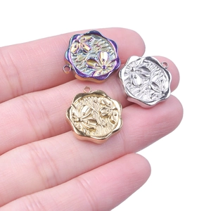 Macro view of floral embossed 304 stainless steel pendants in gold, silver and rainbow colors