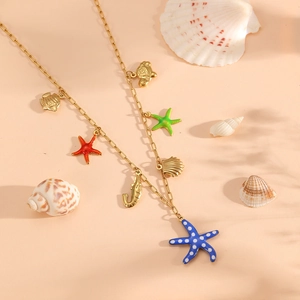 Golden titanium steel necklace with starfish and seashell charms on a beach setting