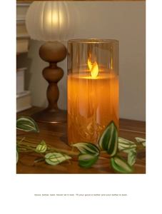 Detail of amber glass LED candle with flickering flame on a rustic wooden table