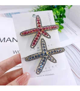 Macro view of crystal starfish hair clips featuring pink, blue, and purple rhinestones