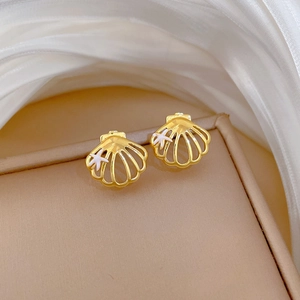 Elegant gold shell earrings with starfish detail on a premium jewelry box