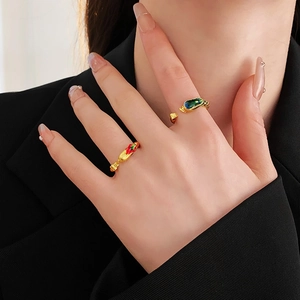 Macro detail of gold-plated dragon and phoenix rings with green and red enamel