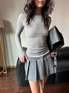 Detailed texture of grey slim-fit wool T-shirt and matching pleated mini skirt set