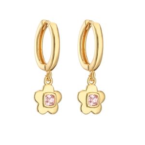 Macro detail of golden huggie hoop earrings featuring a floral pendant with pink zircon