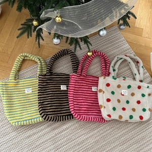 Flat lay of colorful plush tote bags with stripe and polka dot patterns on a beige rug