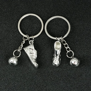 Detailed close-up of metallic silver soccer shoe and ball charms on a keychain