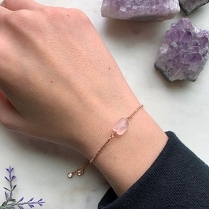 Detail of adjustable 14K rose gold plated chain with natural pink crystal stone on wrist