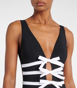 Detail of V-neck one-piece swimsuit with black body and contrasting white bow ties