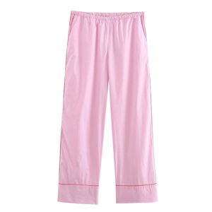 Dettaglio di pantaloni relax rosa con profili rossi ed elastico in vita su sfondo bianco