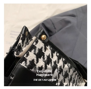 Macro shot of houndstooth fabric with premium gold metal rivets and black leather piping