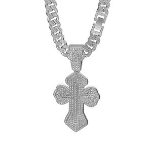 Macro shot of silver hip-hop Cuban chain necklace with iced out cross pendant details