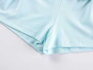 Detailed close-up of light blue knitted sleepwear shorts with high-quality stitching detail