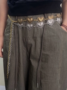 Detail of vintage carved heart-shaped metal waist chain with baroque pattern