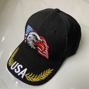 Detalle de águila bordada, bandera USA y hojas de laurel doradas en gorra de algodón negra