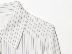 Detailed view of the collared neckline and vertical stripes on white shirt dress