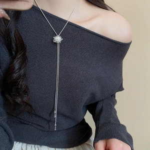 Macro detail of silver Y-shaped necklace with elegant zircon sunflower pendant on model