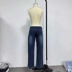 Vista dettagliata dei jeans in denim lavato blu scuro con doppie tasche applicate posteriori