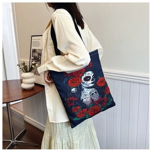 Detail of canvas tote bag with Day of the Dead skull and red rose print on black