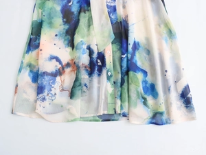 Κοντινό πλάνο σε μπλε και πράσινο ύφασμα tie-dye με λεπτομέρεια κουμπιών στη μπλούζα
