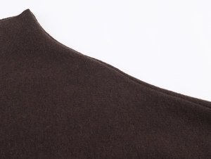 Dettaglio della trama in lana marrone scuro e cuciture precise sullo scialle moda