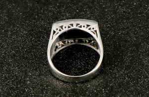 Macro detail of men's stainless steel ring with black zircon stone and filigree sides